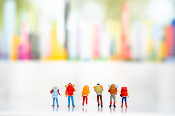 Miniature people: Group of backpacker standing on white background with copy space using as background business trip travel on city concept.