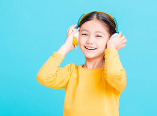 Happy little girl   listens to music in headphones