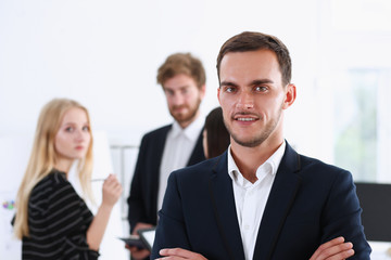 Fototapeta premium Handsome man in suit and tie look in camera hands crossed on chest background. White collar dress code modern office lifestyle graduate college study profession idea coach train concept