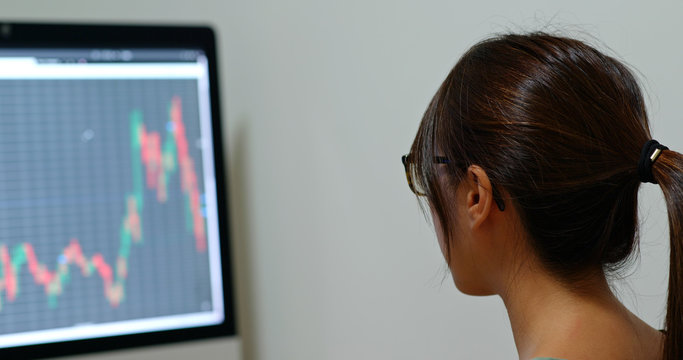 Woman look at the stock market graph at office