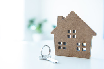 House shape toy with keychain on white table and blank background.