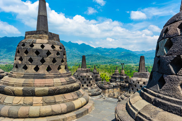 Some stupas in Borobudur Temple, Magelang, Indonesia; with rural Central Java hilly scenery in the background. Borobudur Temple will be the location to celebrate Vesak Day.