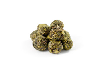 Pile of dry green tea oolong leaves on a white background close-up. Bolls.
