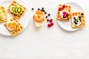 Fototapeta na wymiar Breakfast with freashly baked belgian waffles on white background top-down frame copy space