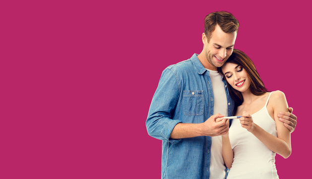 Love, relationship, new parents and happy family concept - young couple, finding out results of a pregnancy test. Over red background. Copy space for some text.