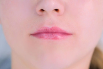 Woman's lips after permanent makeup microblading procedure, closeup view. Beauty industry concept.