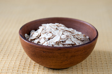 Oatmeal grits in a clay bowl on the table