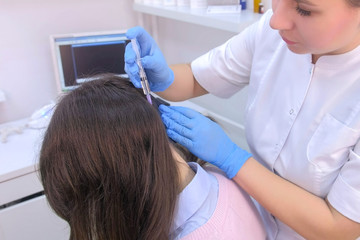 Doctor trichologist making injections mesotherapy in woman skin head for hair growth in cosmetology clinic. Cosmetologist making treatment procedure to patient. Hairs cure. Trichology in medicine.