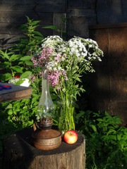 wildflowers bouquet, old kerosene lamp and apple
