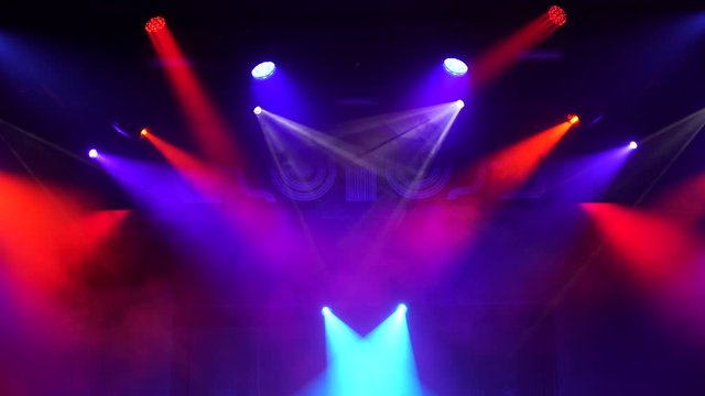 Setting up the stage light before the show. Bright multi-colored rays of spotlights, geometric patterns on a black background. ultraviolet light 4K, blue, violet colors