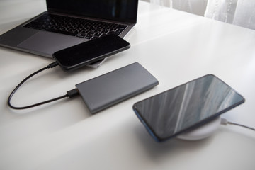 laptop with smart watch computer mouse and phone charging on wireless charger