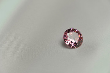 pink round gem cut on beige fabric fashion background