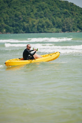 Young man with paddle kayaking in sea on sunny day