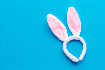 Easter bunny concept. Toy rabbit's ears for head on blue background top-down copy space