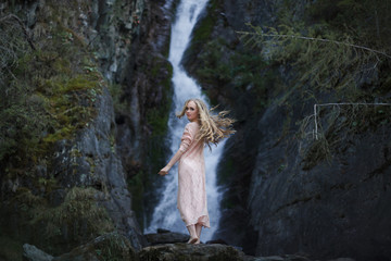 Girl on the background of a waterfall
