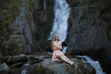 Girl on the background of a waterfall