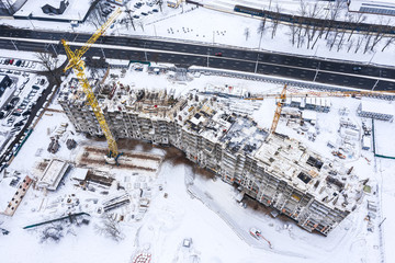 construction of a multi-storey residential building at winter time. aerial view from flying drone