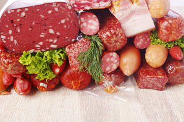 Meat products and greens on a light table