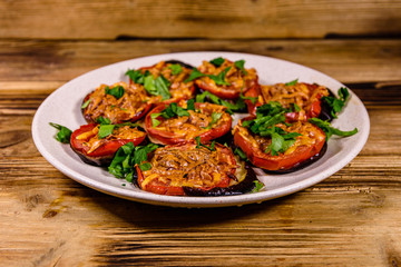 Baked eggplants with tomatoes and cheese in a ceramic plate