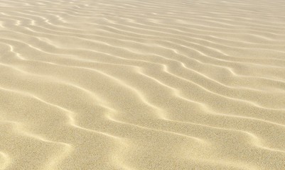 Fototapeta na wymiar Wavey sand on beach under sunlight close-up
