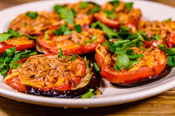 Baked eggplants with tomatoes and cheese in a ceramic plate