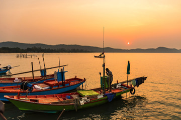 Chanthaburi, Thailand - February, 02,  2020 :Beautiful sunrise over sea with Silhouette of fishermen with yellow and orange sun in the background.
