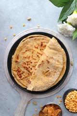 Holi Festival Food - Puran Poli is an Indian sweet flatbread stuffed with mixture of chana dal, jaggery, ghee & cardamom. Usually eaten on Holi or Gudi Padva festival. Recipe ingredients. copy space.