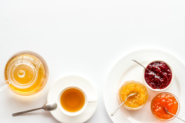 Fruit jam near tea on white kitchen desk frame copy space