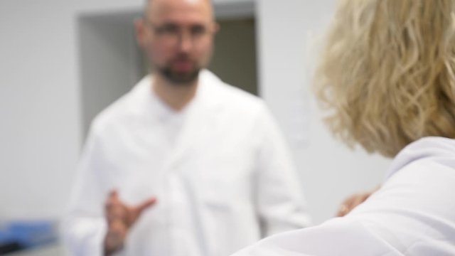 blurry view of 2 doctors discus the patients situation 