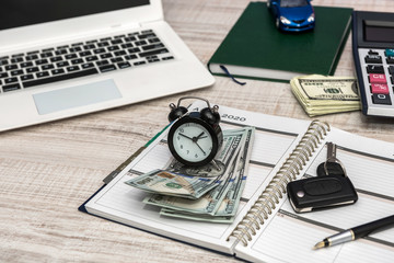 Business - car key, laptop money and notepad on desk
