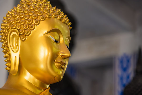 Close up gold Buddha face statue.