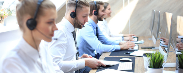 Portrait of call center worker accompanied by his team. Smiling customer support operator at work.