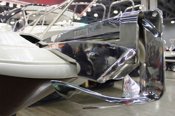 Shiny stainless steel 7.5 kg anchor with roller on forepeak of a motor boat © Ilya