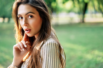 Young beautiful woman outdoors on green background summer nature