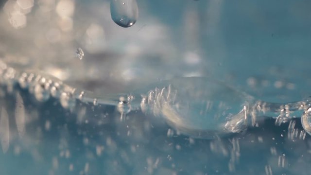 Pouring sparkling water into a glass, macro