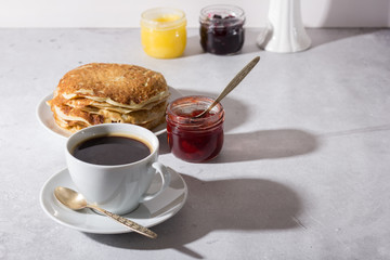 Delicious breakfast - coffee and homemade pancakes with jam. Filmed on a light background.
