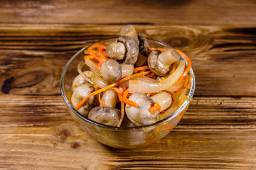 Canned mushrooms with carrot and onion in a ceramic bowl