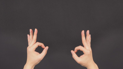 The A-Ok Hand Sign on with two male 's hands black background.