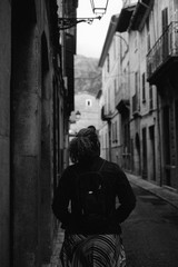 Fototapeta na wymiar Girl walking down Spanish street, black and white 