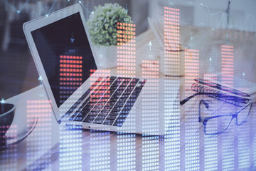 Stock market graph on background with desk and personal computer. Double exposure. Concept of financial analysis.