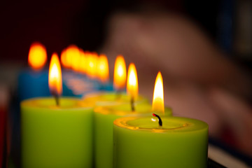 blue and green candles burning in the dark