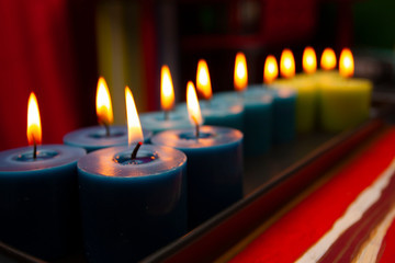 blue and green candles burning in the dark