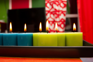 blue and green candles burning in a colored interior