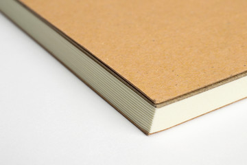 Macro of blank notebook corner with cardboard hardcover isolated on white as template for presentation, showcase design logo, embossing etc.