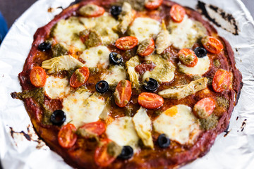 homemade vegetables pizza with olives and cherry tomatoes topping