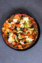 homemade vegetables pizza with olives and cherry tomatoes topping