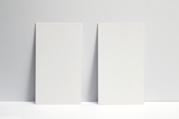 2 blank business cards locked on white wall, 3.5 x 2 inches size as template for design presentation, showcase et