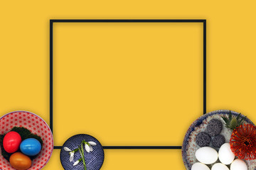 Top view flat lay Easter concept with black frame and yellow background