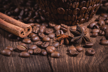 Obraz na płótnie Canvas Coffee Beans Cinnamon Stick Anise Star Wooden Table Close-up. Background for coffee beans in dark colors for the background.