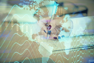Multi exposure of hands making notes with forex chart huds. Stock market concept.
